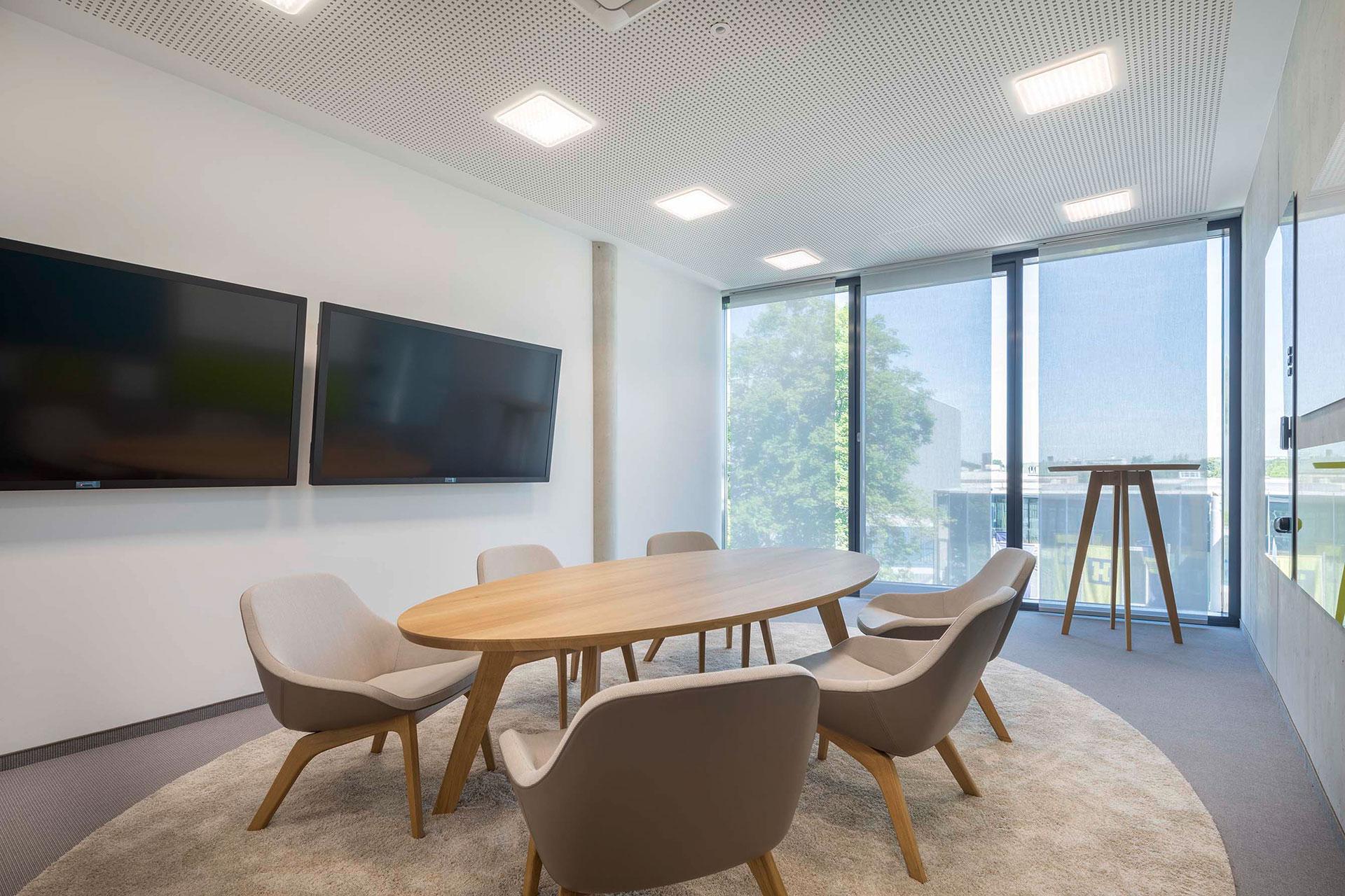 Technisch voll ausgestatteter Konferenzraum für hybrides Arbeiten mit moderner Medientechnik und integriertem Lichtkonzept von freiraum.