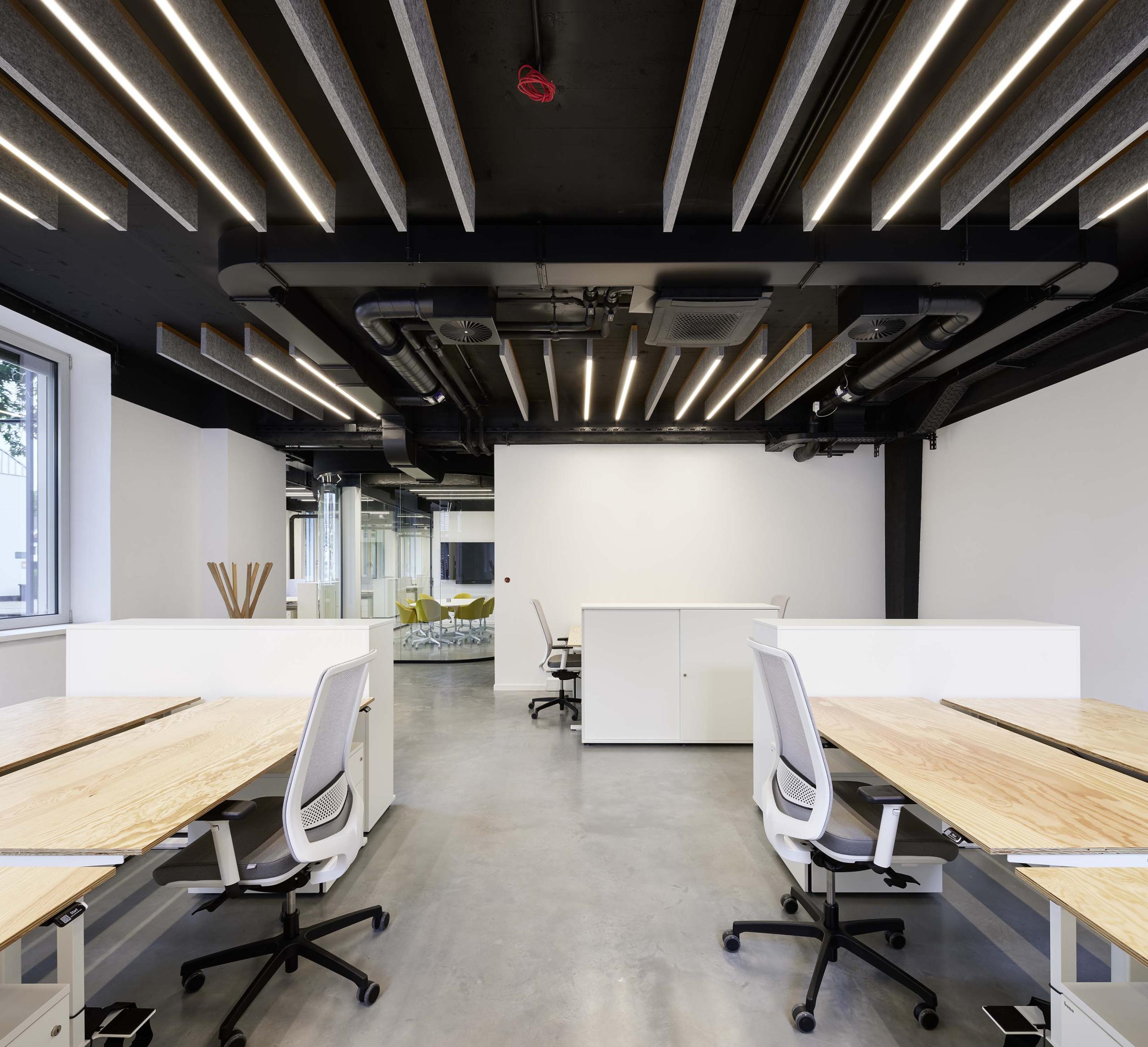 Helle, offene Arbeitslandschaft im New-Office-Design mit Desk-Sharing-Arbeitsplätzen und integrierten Teambereichen zur nachhaltigen Steigerung der Flächeneffizienz.